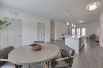 A dining room with a round table and chairs.