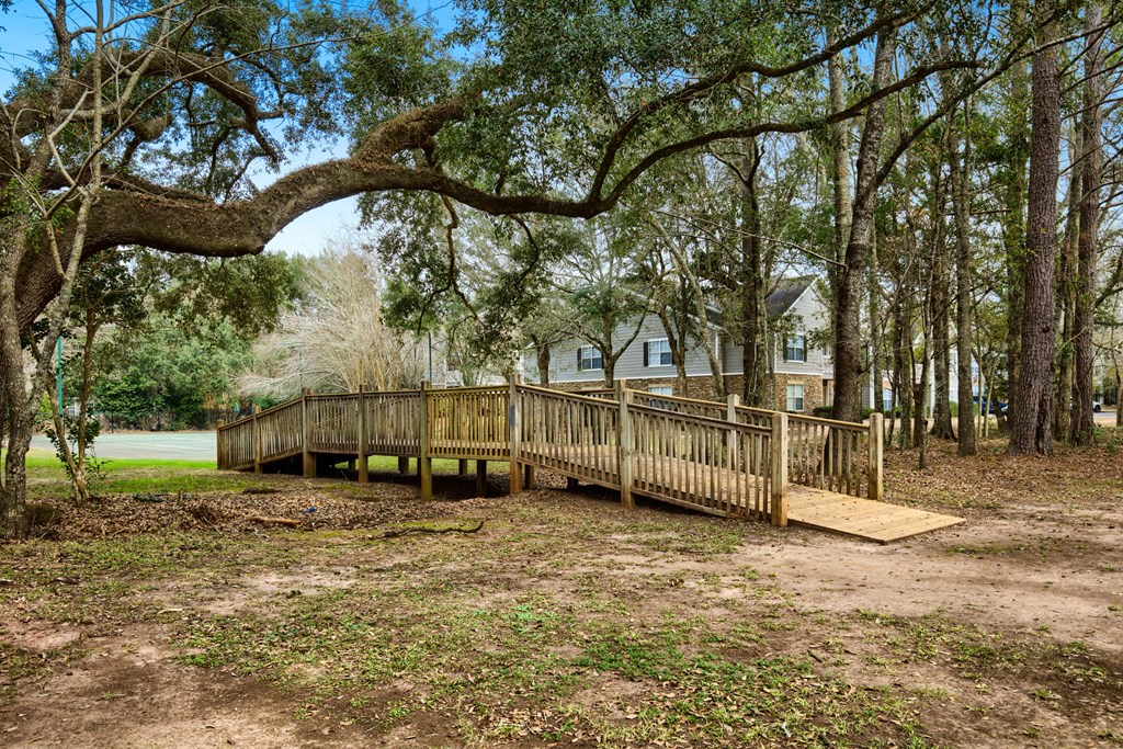 a wooden bridge in front of a house
