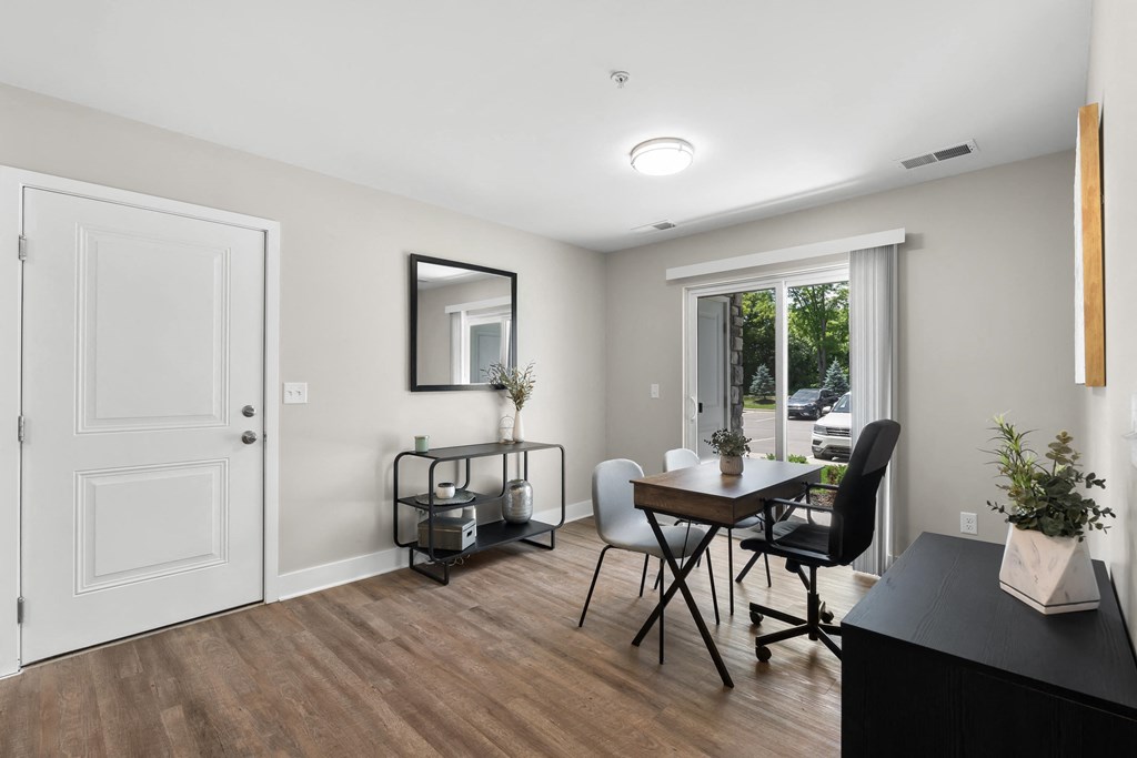 a living room and dining room with a table and chairs and a window