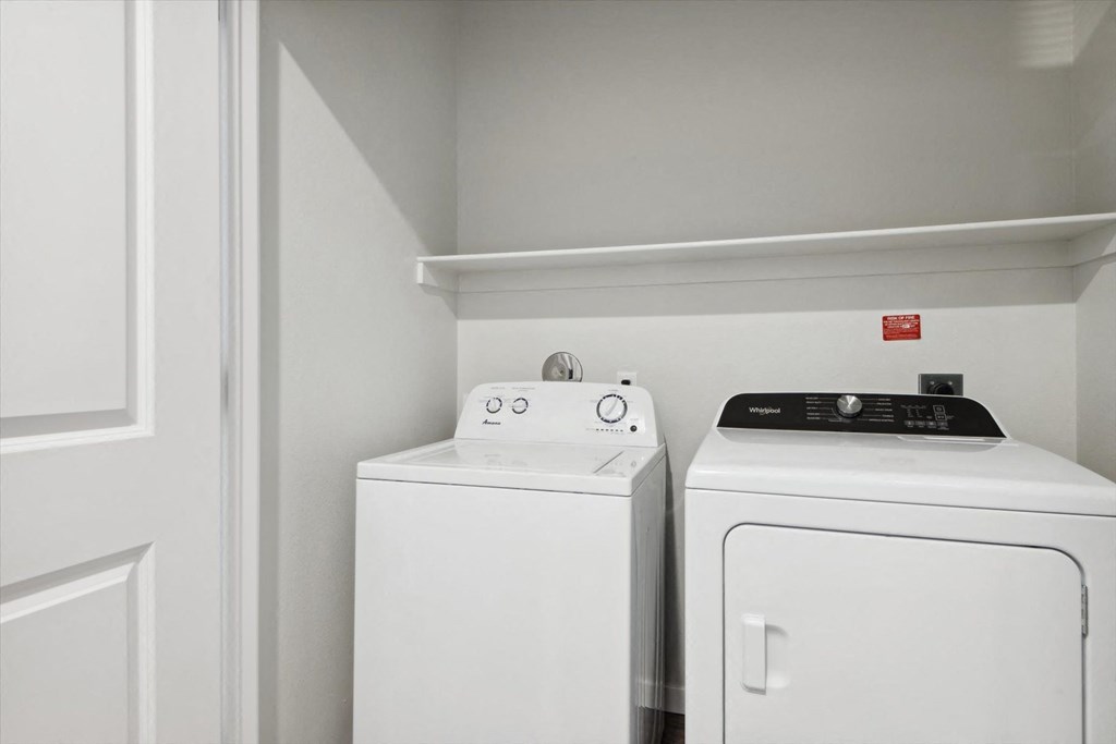 a white washer and dryer in a room with white walls and white appliances