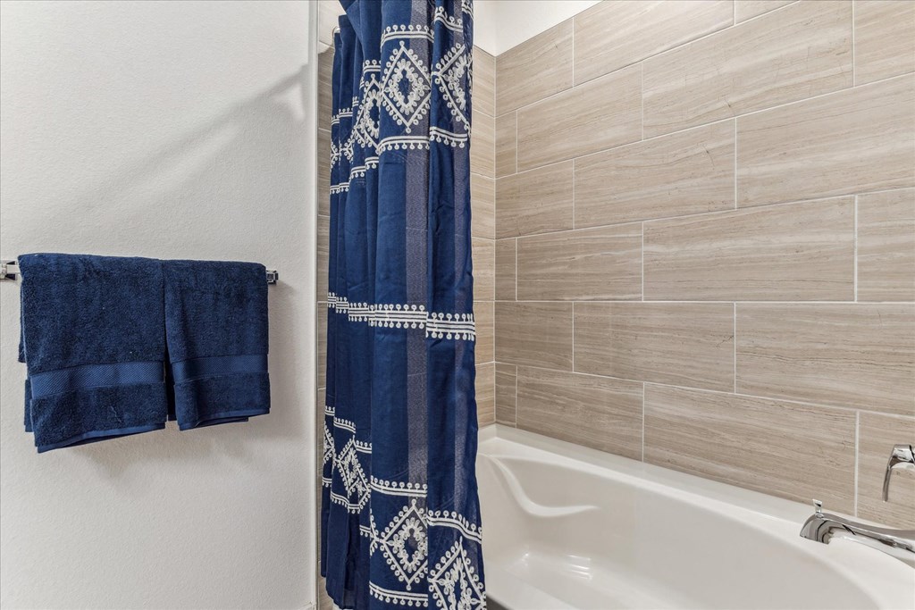 a bathroom with a bath tub and a shower curtain
