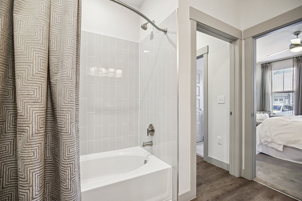 A bathroom with a white tub and a shower curtain.