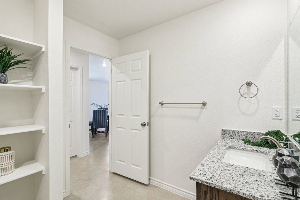 A white bathroom with a sink and a mirror.