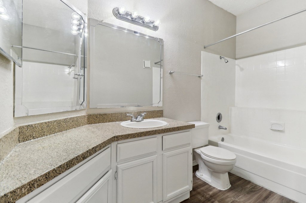 A white bathroom with a sink, toilet, and bathtub.