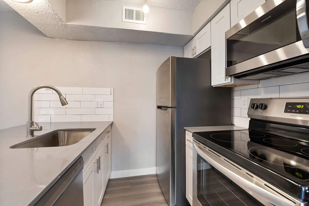 a kitchen with white cabinets and stainless steel appliances