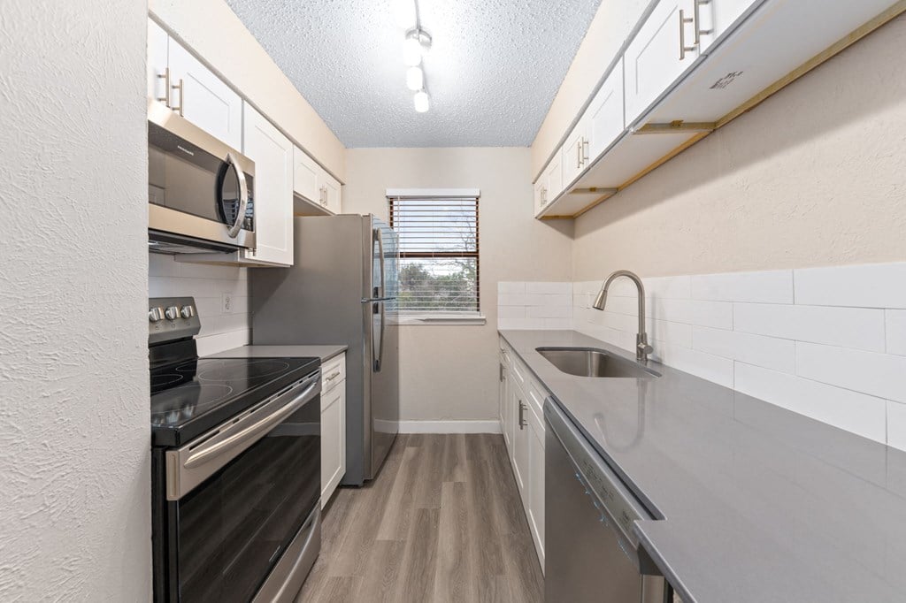 a kitchen with white cabinets and stainless steel appliances
