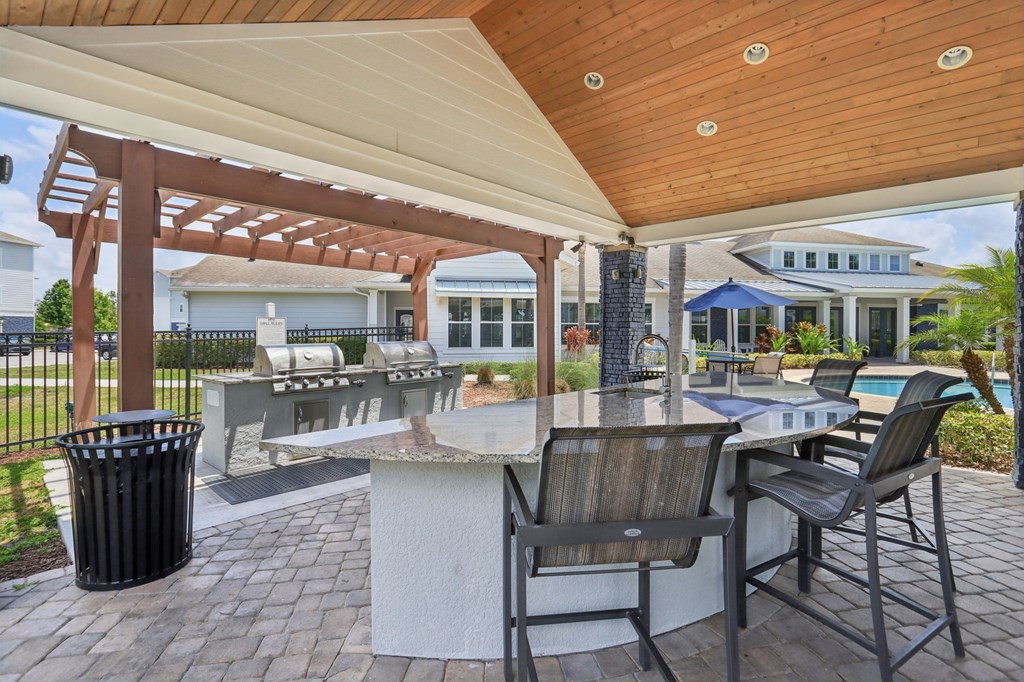 A patio with a table and chairs under a pergola.