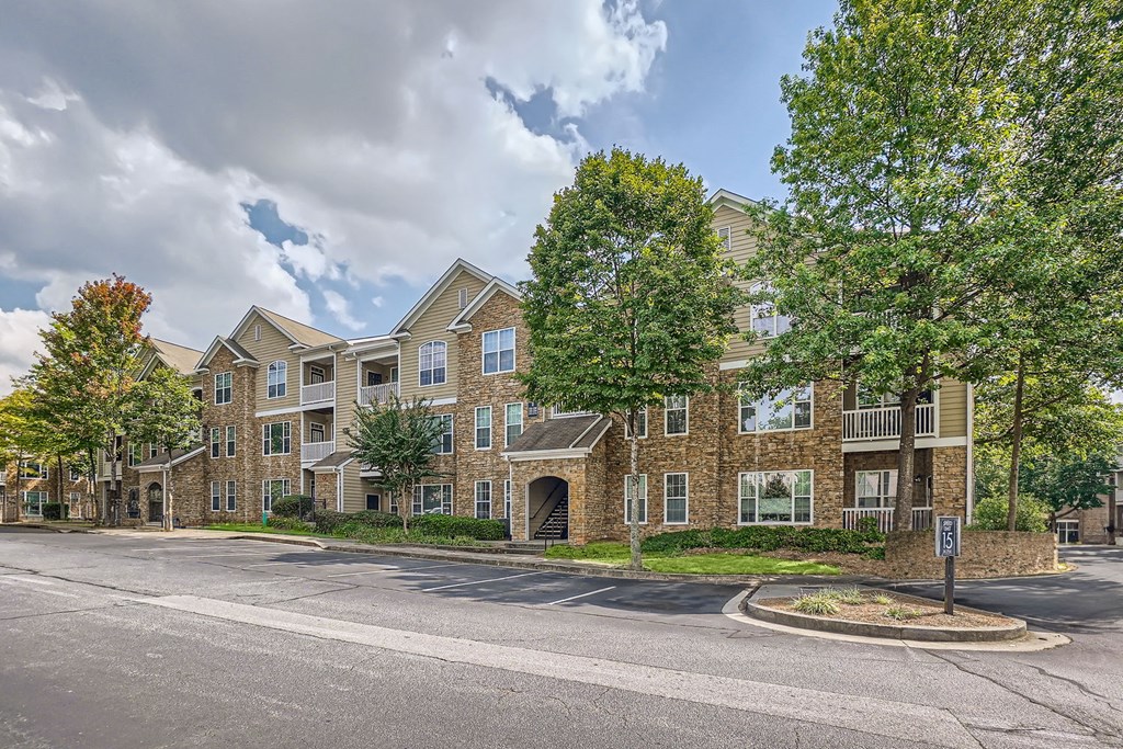 A large apartment complex with a parking lot in front.