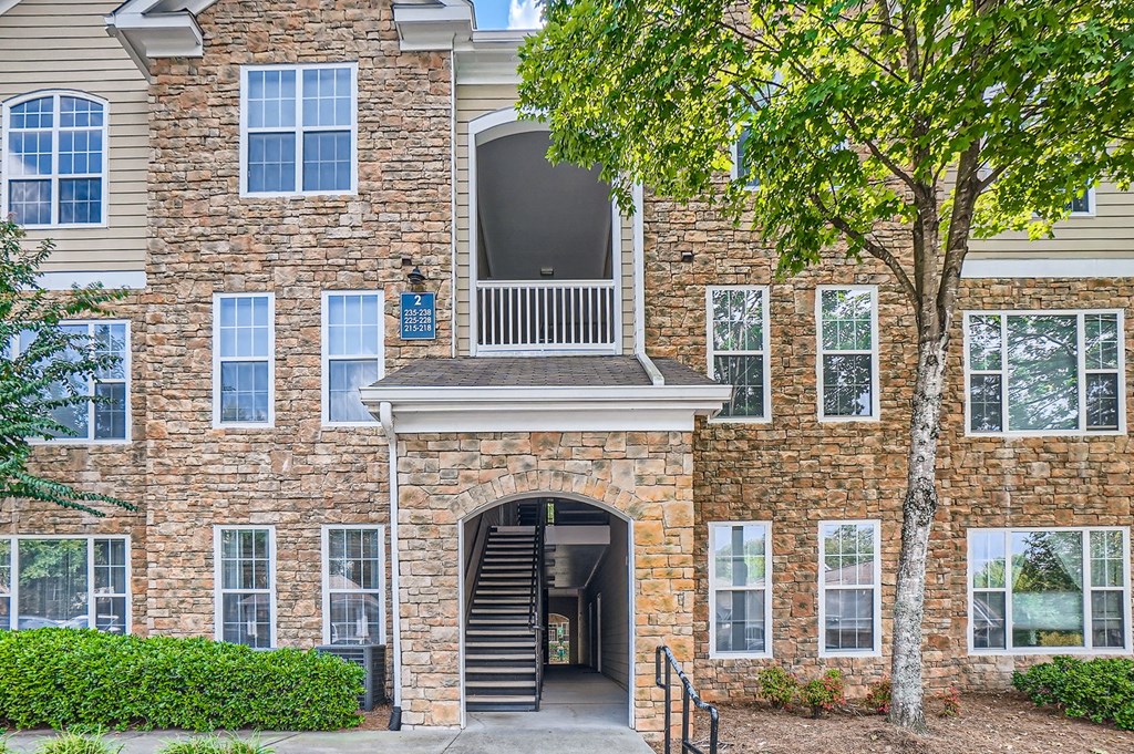 A stone building with a tree in front.