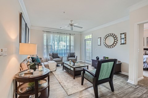 A living room with a dark wood floor and furniture.
