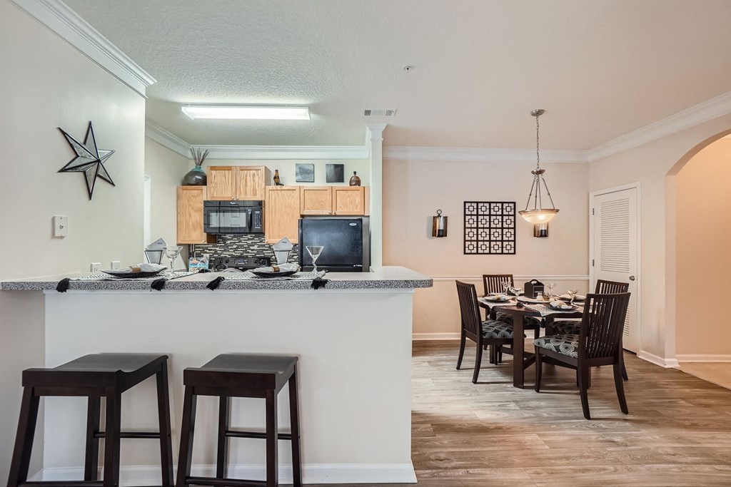 A kitchen with a bar and a dining table.