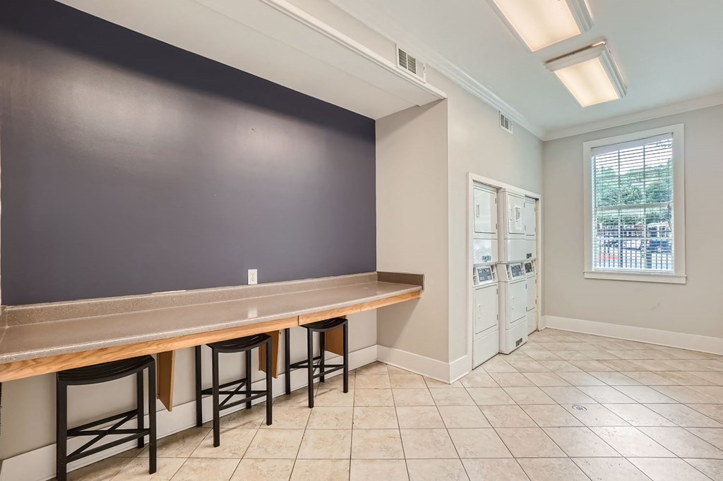 A kitchen with a counter and bar stools.