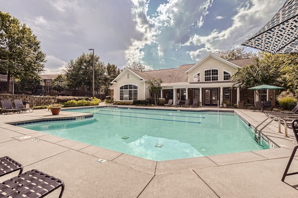A large swimming pool in front of a house.
