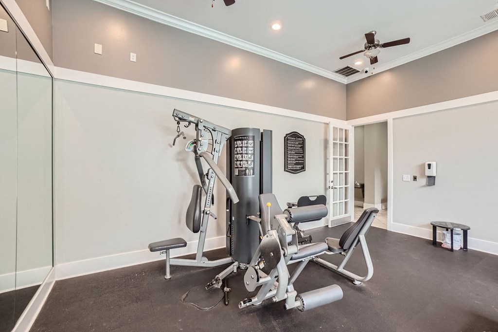 A home gym with a weight machine and a bench.