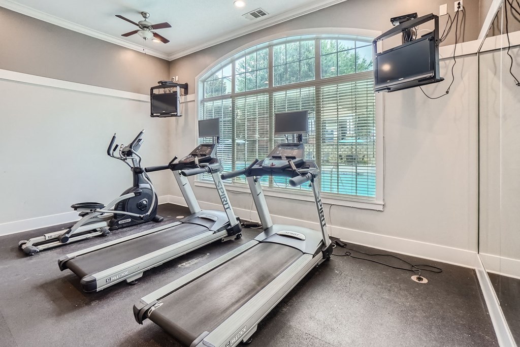A home gym with treadmills and elliptical machines.