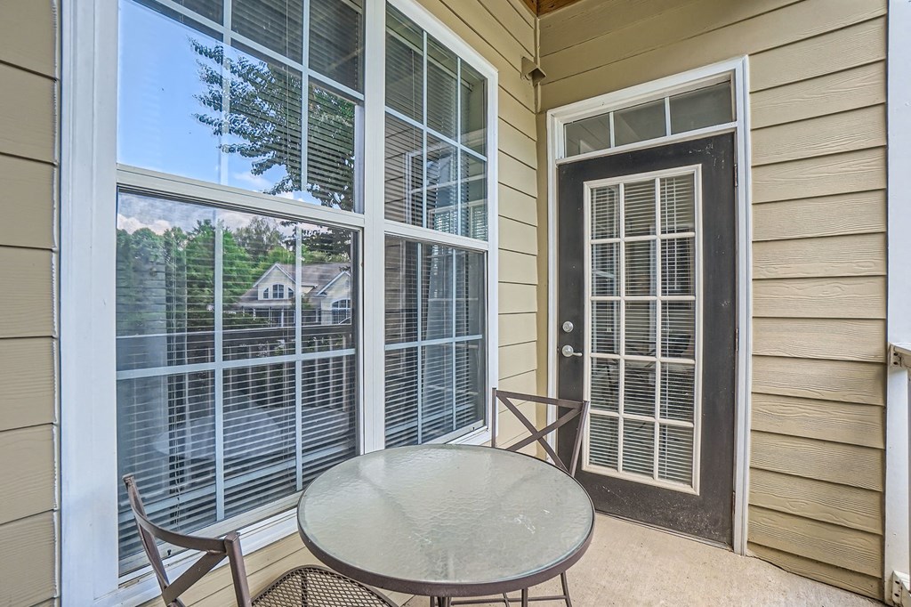 A patio with a table and chairs and a sliding glass door.