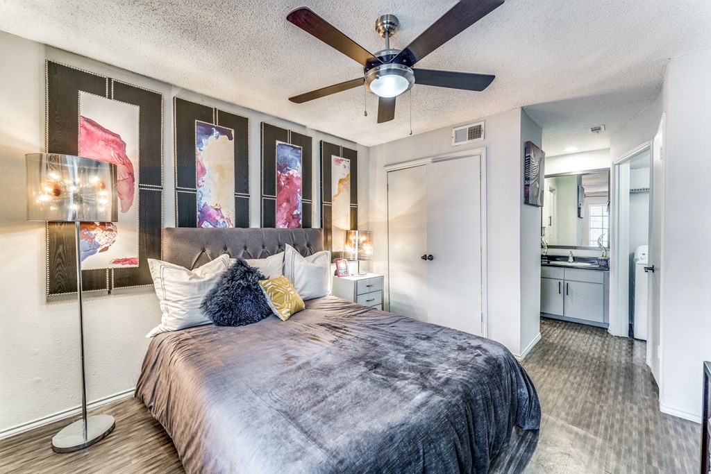 a bedroom with a large bed and a ceiling fan