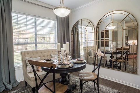 A dining room with a round table and chairs.