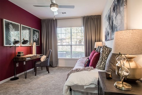 A bedroom with a bed, desk, and chair.