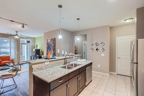A kitchen with a sink, refrigerator, and a counter with a bowl on it.