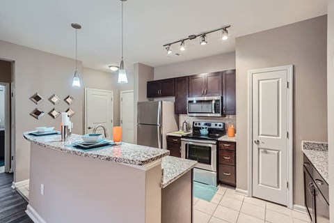 A kitchen with a granite countertop and stainless steel appliances.
