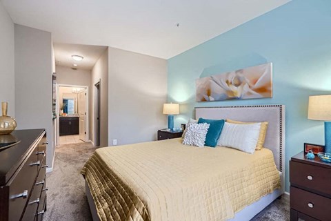 A bedroom with a large bed and a painting on the wall.