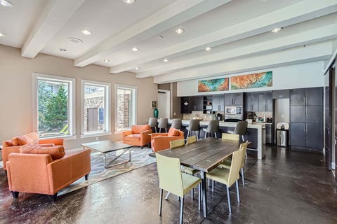 A modern kitchen and living room with a dining table and chairs.