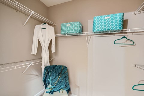 A white robe hanging on a rack in a room.