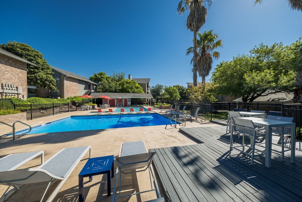 pool side with lounge chairs and tables
