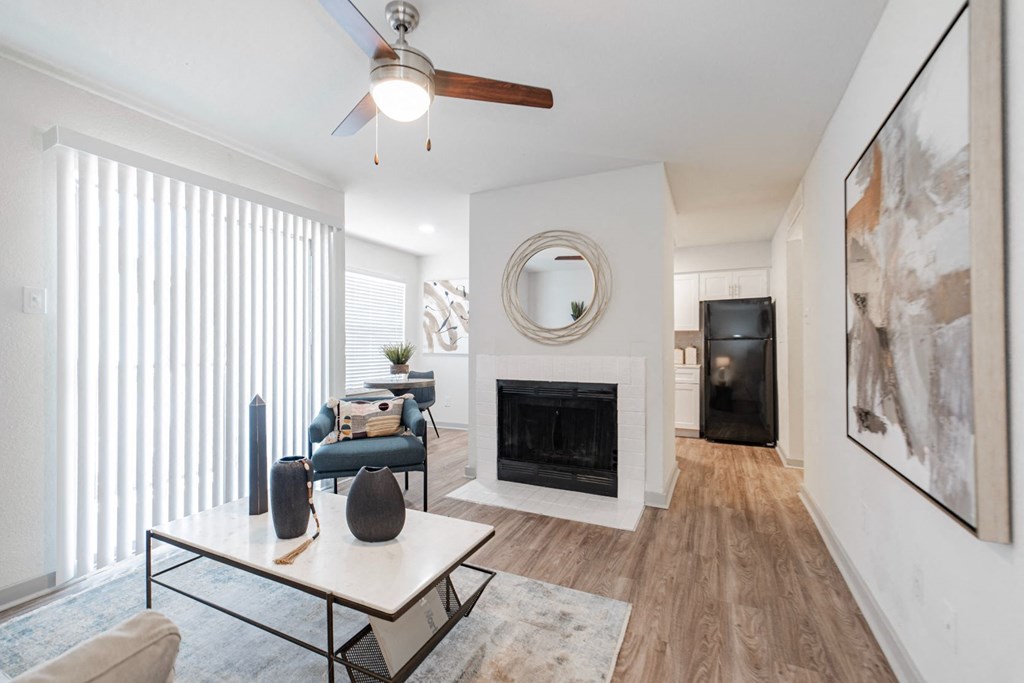 A living room with a fireplace and a painting on the wall.