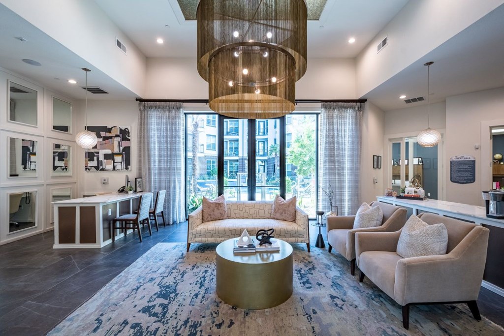 A living room with a large window, a sofa, a coffee table, and a chandelier.
