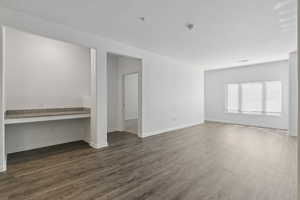 A large empty room with wooden floors and white walls.