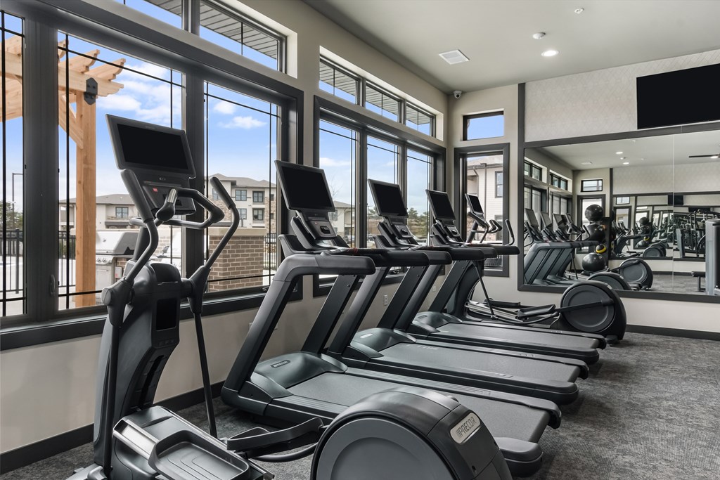 A gym with treadmills and elliptical machines.