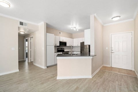 a living room with a kitchen in the background