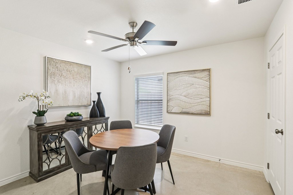 A dining room with a table and chairs.