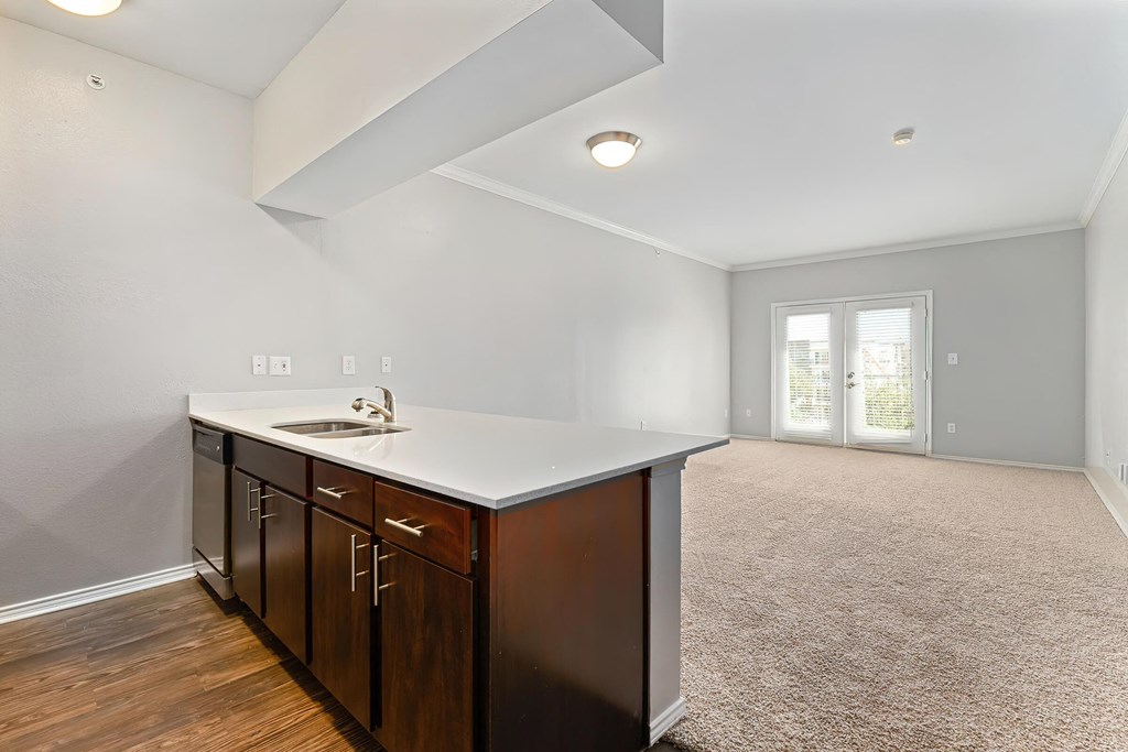 a kitchen with white countertops and dark wood cabinets