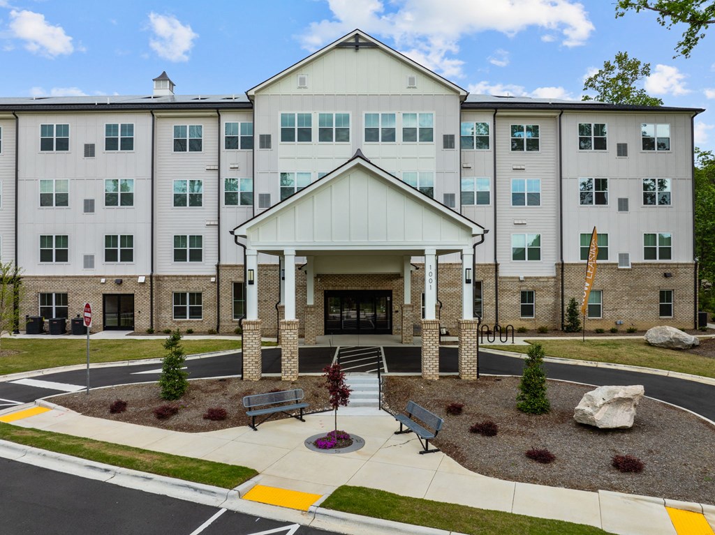 an exterior view of an apartment building with a courtyard and benches