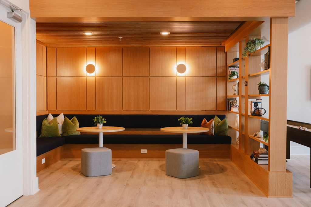 a lounge area with wooden walls and tables and benches