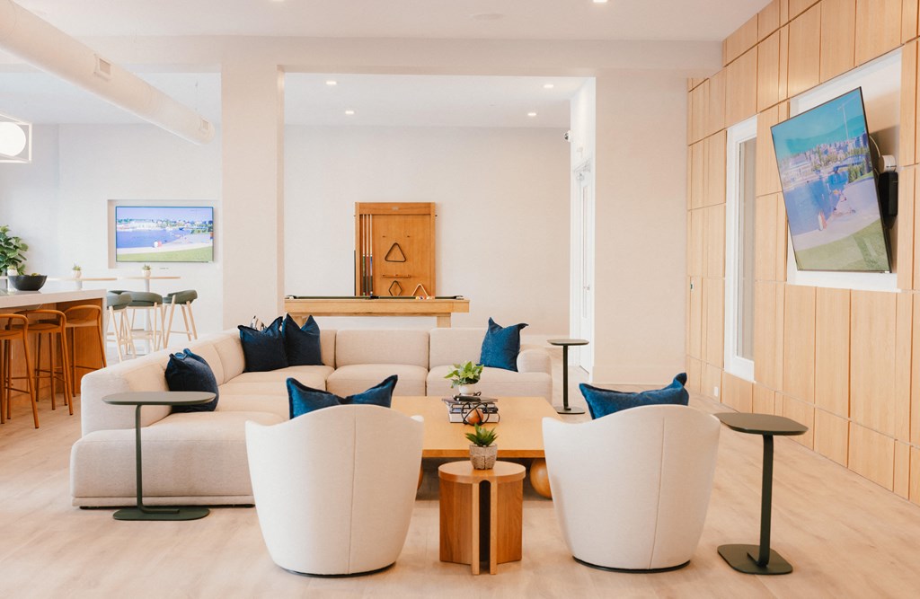 a living room with a couch and chairs and a kitchen