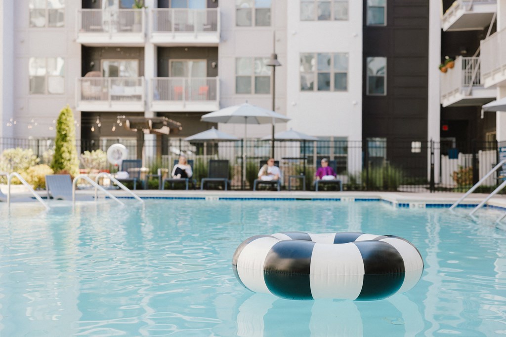 a lifeguard buoy in a swimming pool with an apartment building in the background