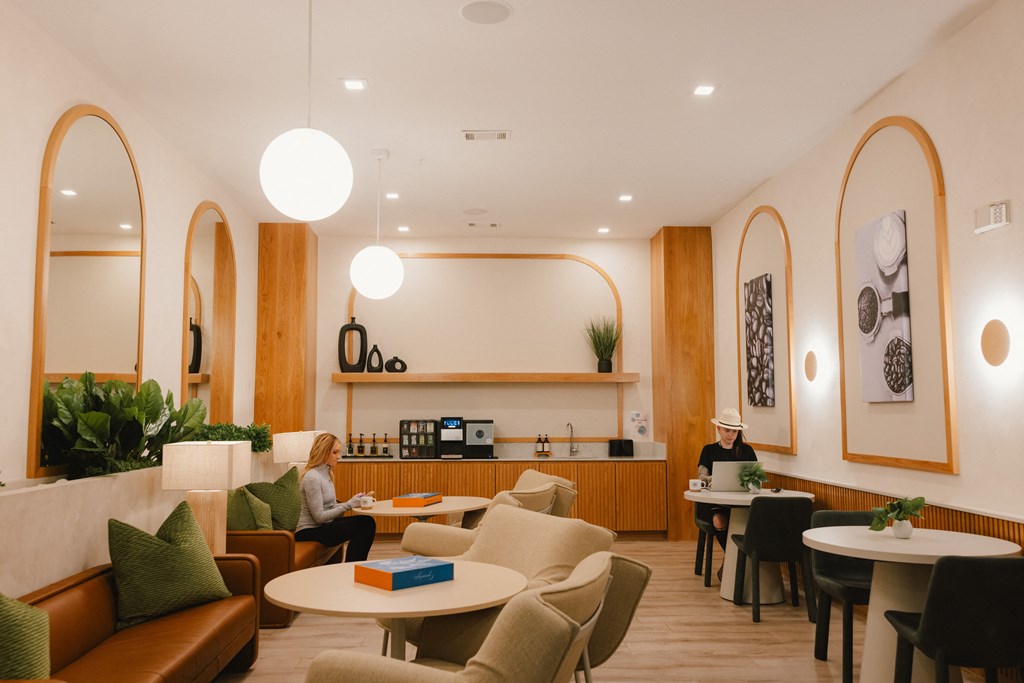 the lobby of a hotel with people sitting at tables