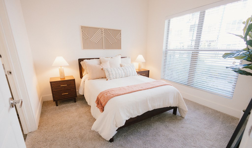 a bedroom with a bed and a large window