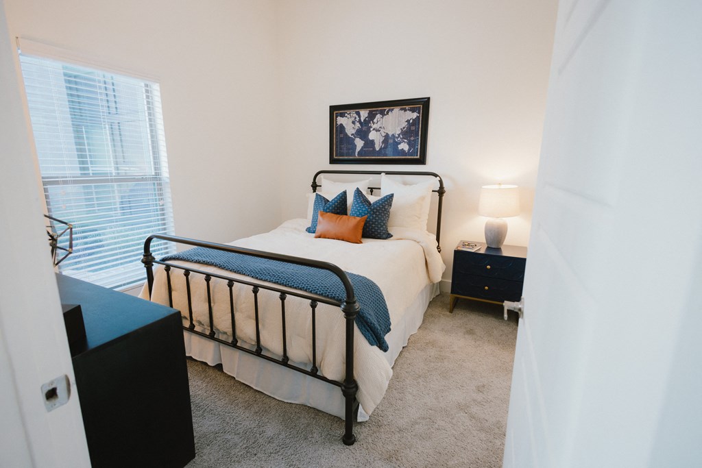 a bedroom with a bed and a dresser and a window