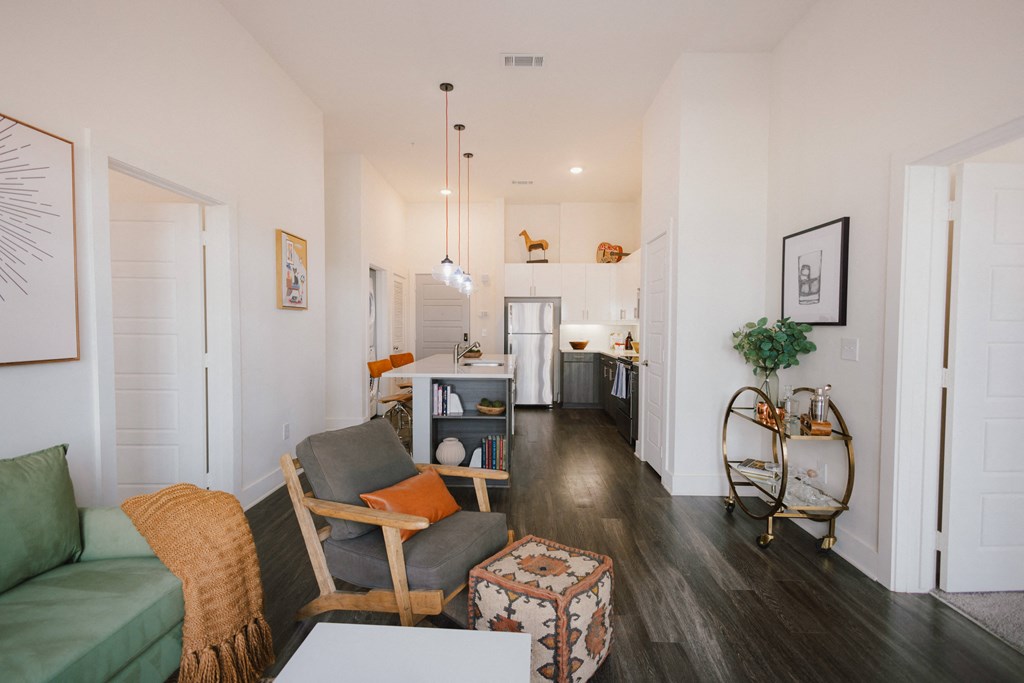 a living room with a couch and a chair and a kitchen