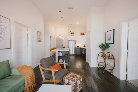 A living room with a green couch and a wooden chair.