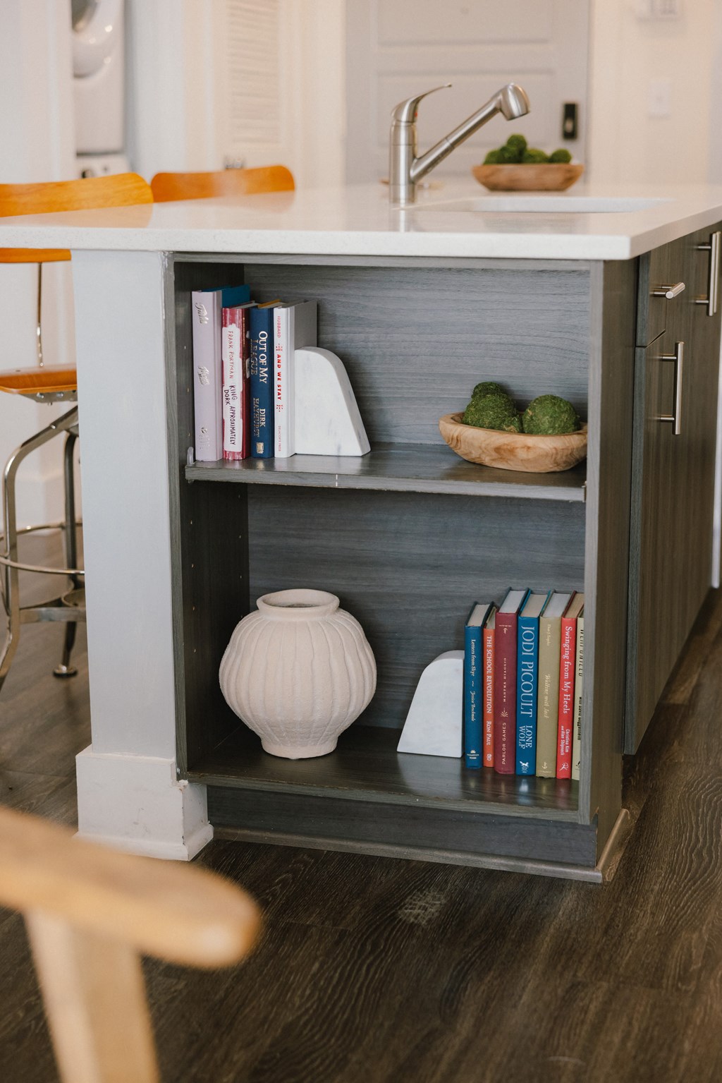 a bookshelf in a kitchen with a sink and books