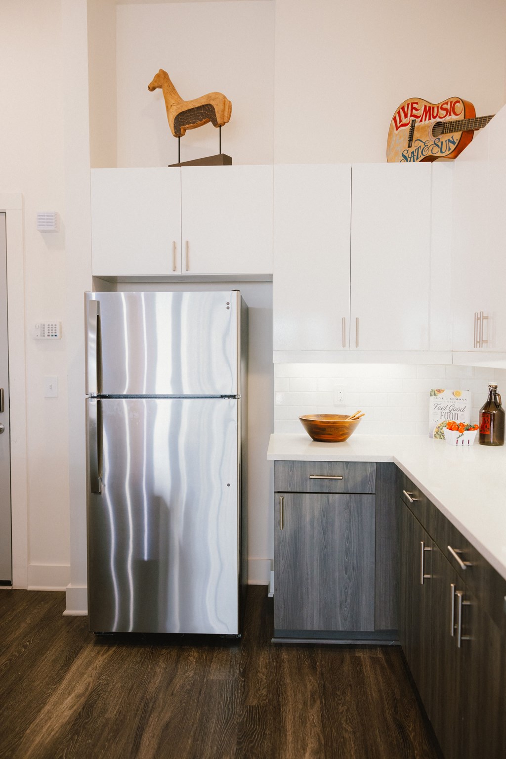 a kitchen with white cabinets and a stainless steel refrigerator