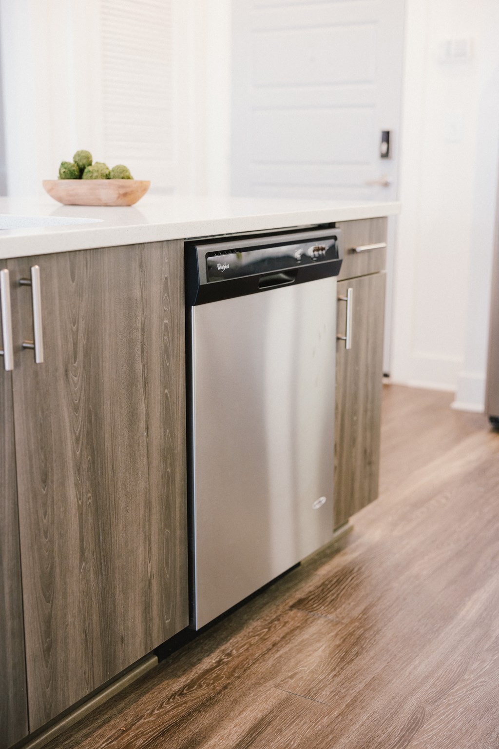 a kitchen with a white counter top and a stainless steel dishwasher