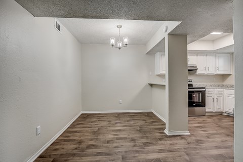 an empty kitchen and living room with wood flooring