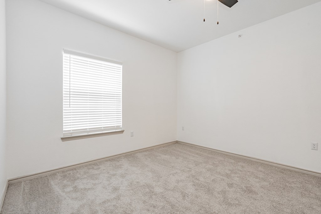 an empty room with white walls and a window